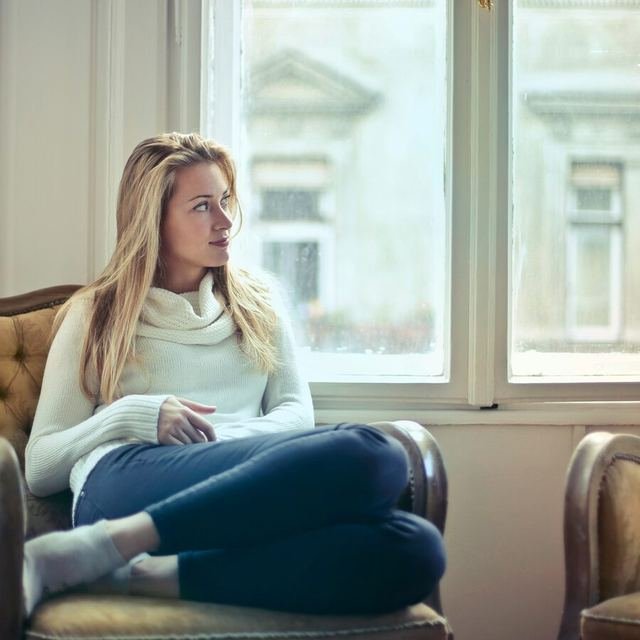 Mulher pensativa, recolhida, representando dificuldade em dizer não